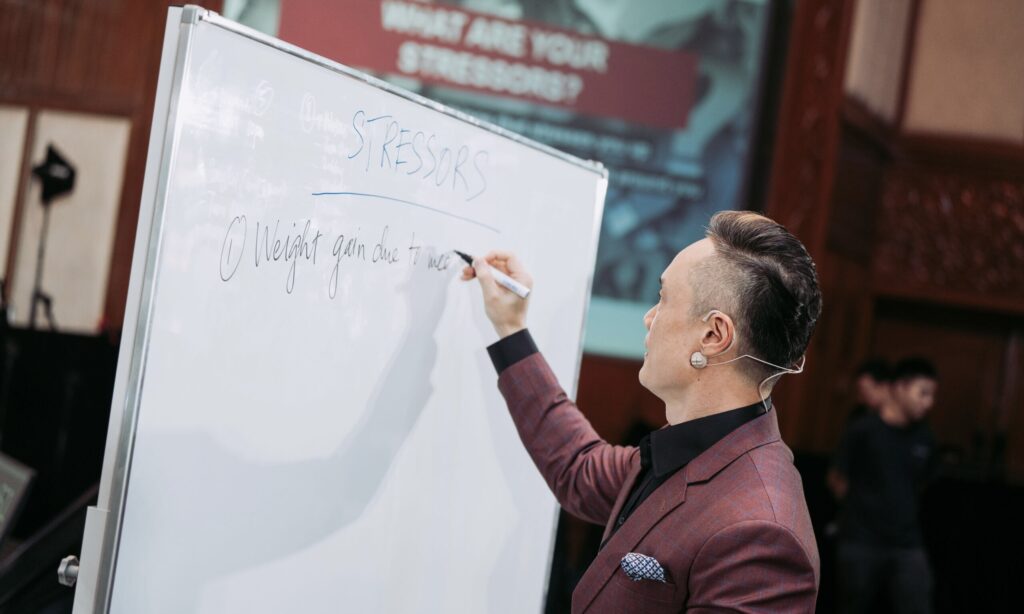 Trainer writing on a whiteboard at a leadership workshop Singapore session